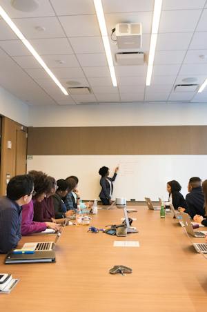 A project discussion around a meeting table and whiteboard